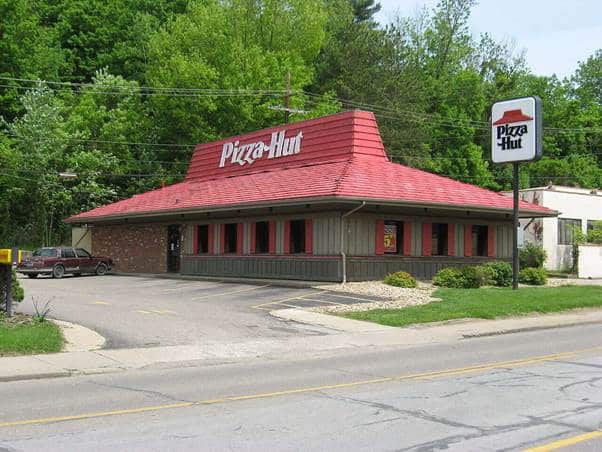 A pizza hut restaurant with a red roof AI-generated content may be incorrect.
