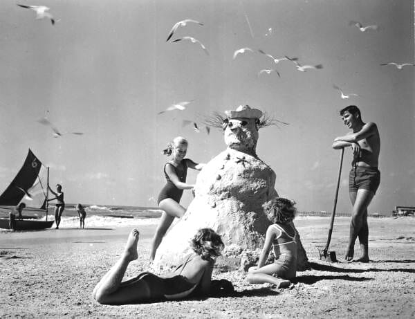Three girls making a ‘sandman’ at the beach