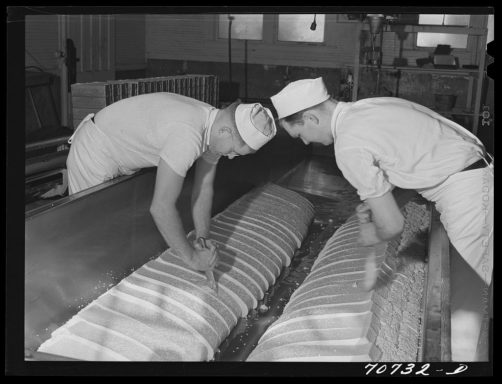 Cutting through the curd which has cheddared, and thus releasing the whey. Tillamook cheese plant, Tillamook, Oregon (1941 Oct.)