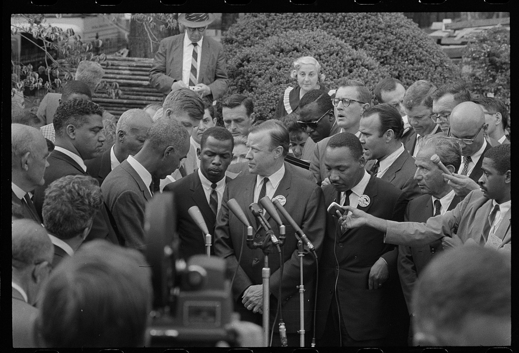 Civil rights leaders talk with reporters after meeting with President John F. Kennedy after the March on Washington, D.C. — Photograph includes Martin Luther King, Jr.(SCLC) and John Lewis (SNCC). (1963 Aug. 28)