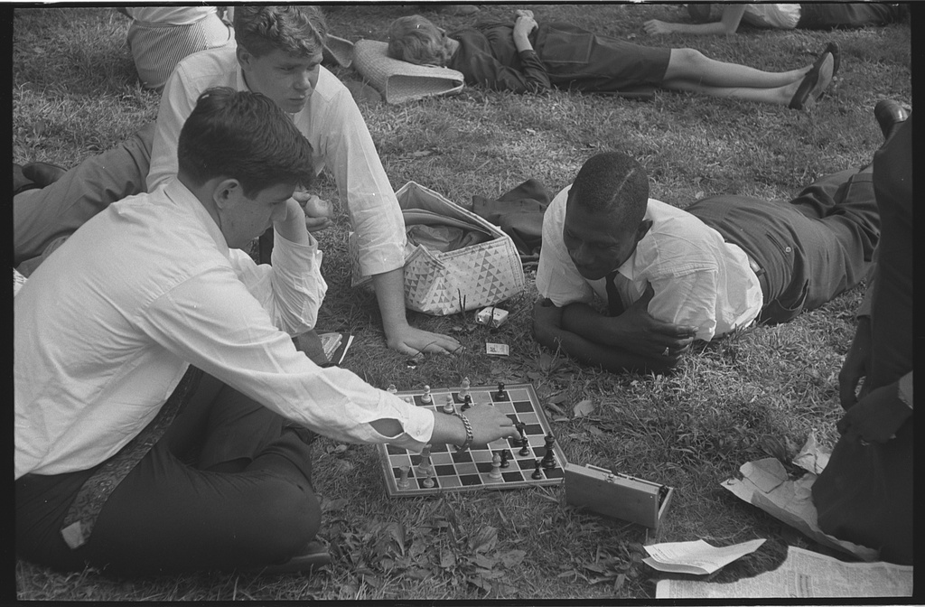 Young men participants in the March on Washington playing chess on the grass (1963 Aug. 28)