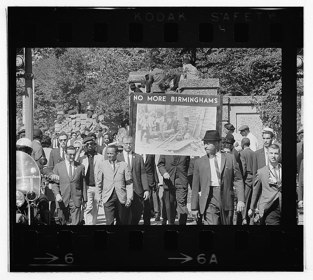 Congress of Racial Equality conducts a march in memory of Black youngsters killed in Birmingham bombings, All Souls Church, 16th Street, Washington, D.C. — Photograph showing people marching and carrying a sign that says "No More Birminghams." (1963 Sep. 22)