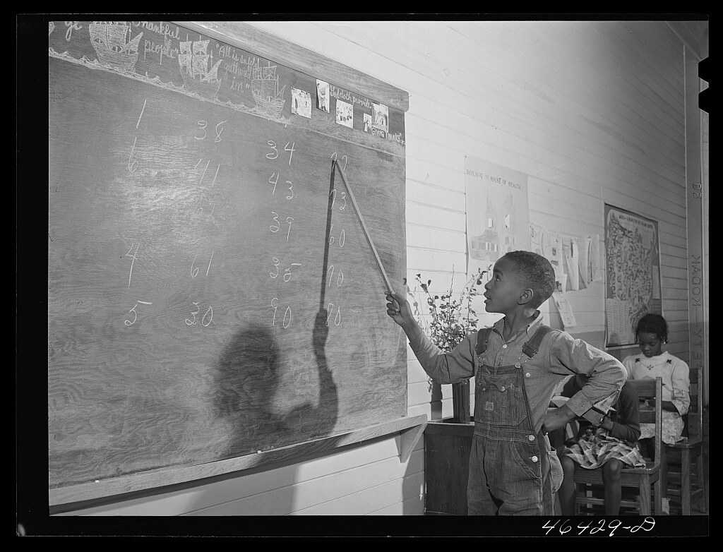 Boyd Jones doing his arithmetic lesson at the blackboard in the Alexander Community School in Greene County, Georgia (1941 Nov.)