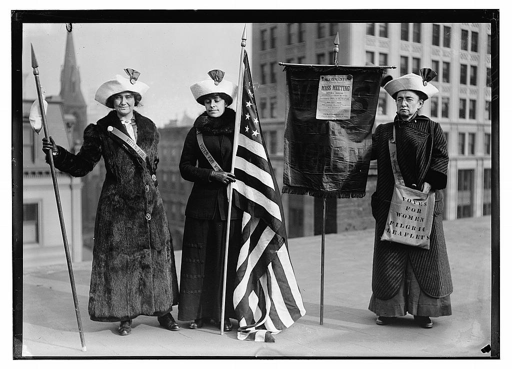 Suffrage hikers with banners and flag