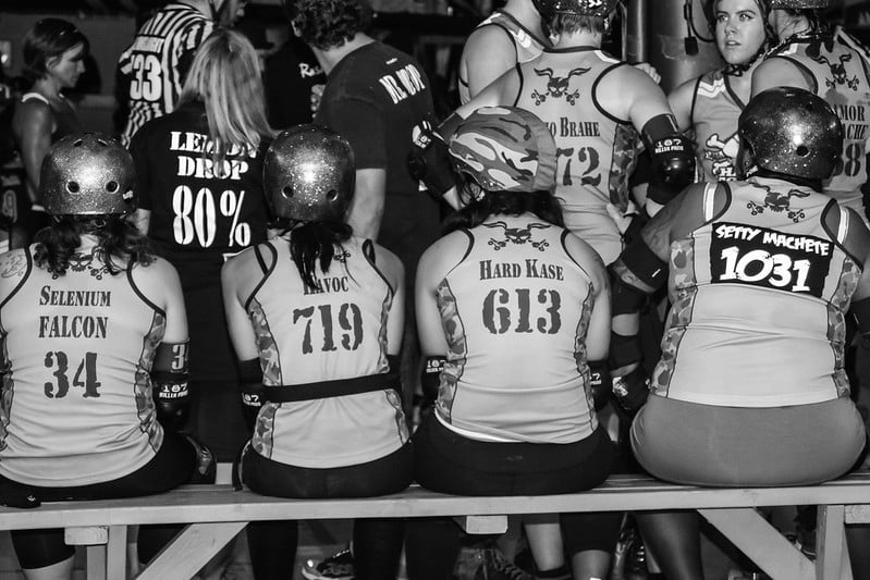 Hard Corps vs The Hustle roller skaters sitting on a bench