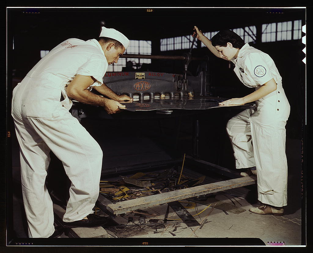 Learning to work a cutting machine, these two NYA employees receive training to fit them for important work, Corpus Christi, Texas. After eight weeks they will be eligible for civil service jobs at the Naval Air Base (1942 August)