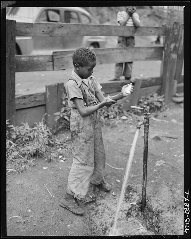 Howard family son washing hands outdoors.